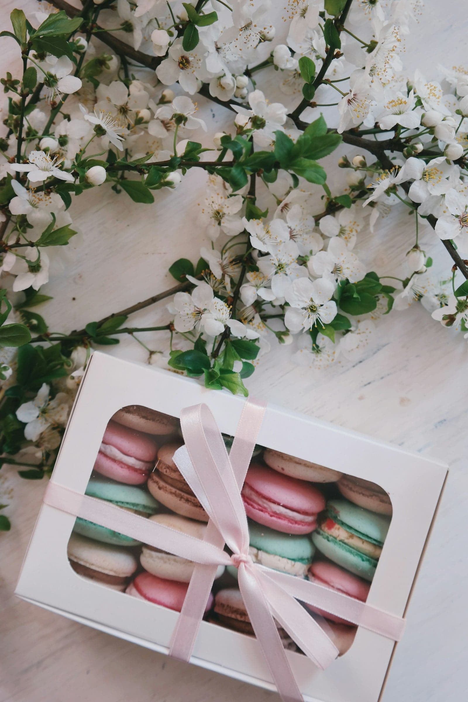 Caixa branca com macarons coloridos e laço rosa